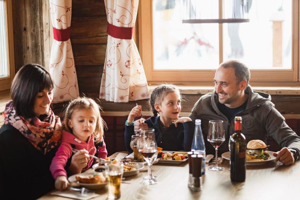 Familie genießt Essen Zirbenhütte Fiss